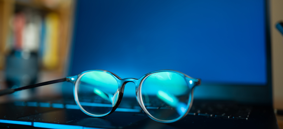 Gafas sobre el teclado de un portátil, mostrando la protección ocular contra la luz azul emitida por las pantallas digitales.
