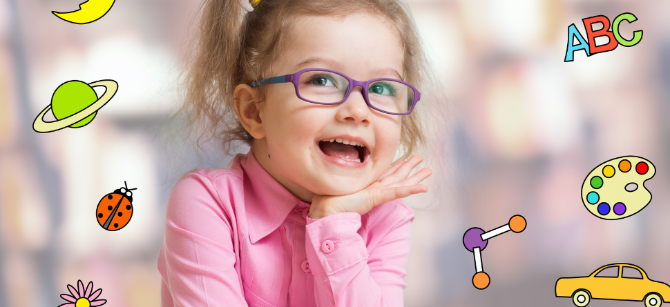 Niña con gafas disfrutando de actividades educativas, resaltando la relación entre el aprendizaje y una buena salud visual en los más pequeños.