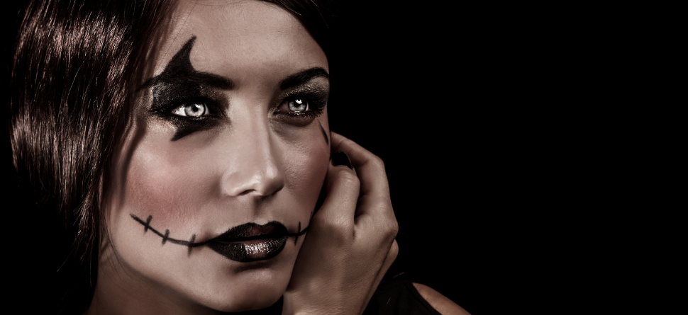 Mujer con maquillaje de Halloween estilo esqueleto y lentillas decorativas blancas que realzan su disfraz, proporcionando un toque misterioso.