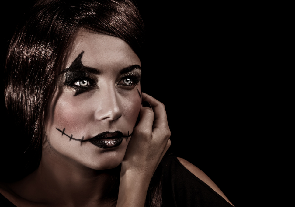 Mujer con maquillaje de Halloween estilo esqueleto y lentillas decorativas blancas que realzan su disfraz, proporcionando un toque misterioso.
