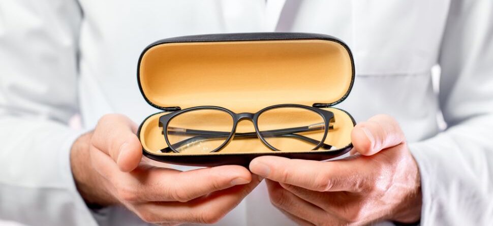 Imagen de un especialista en óptica sosteniendo unas gafas de calidad en su estuche protector, destacando la importancia de elegir gafas certificadas para el cuidado ocular en Óptica Cosmos Tenerife.