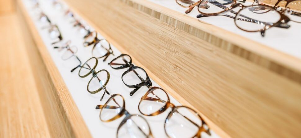 Estante con variedad de modelos de gafas ópticas en exposición, mostrando la amplia selección y calidad que ofrece Óptica Cosmos en Tenerife.