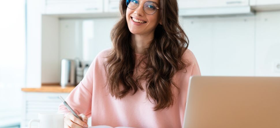 Joven con gafas trabajando en su portátil en Óptica Cosmos La Laguna. Ilustra cómo una revisión visual adecuada mejora la salud ocular en el trabajo y el estudio.