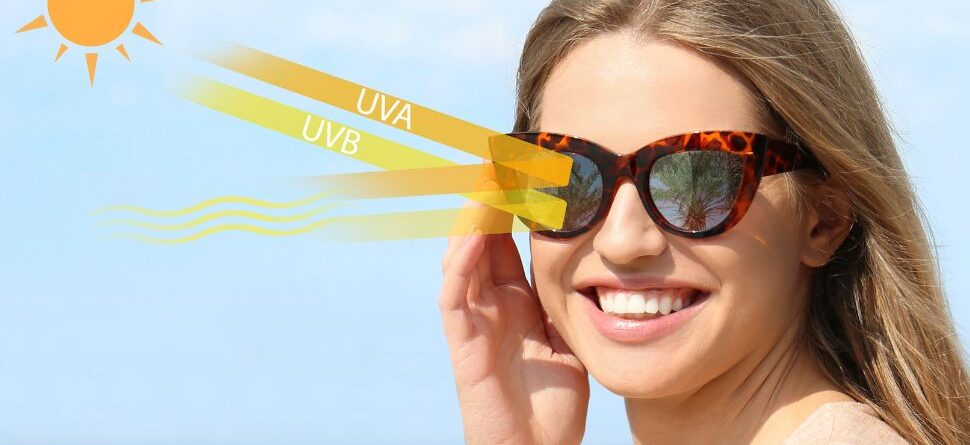 Mujer sonriente con gafas polarizadas que bloquean la radiación UVA y UVB, ofreciendo protección ocular durante actividades al aire libre en Tenerife.