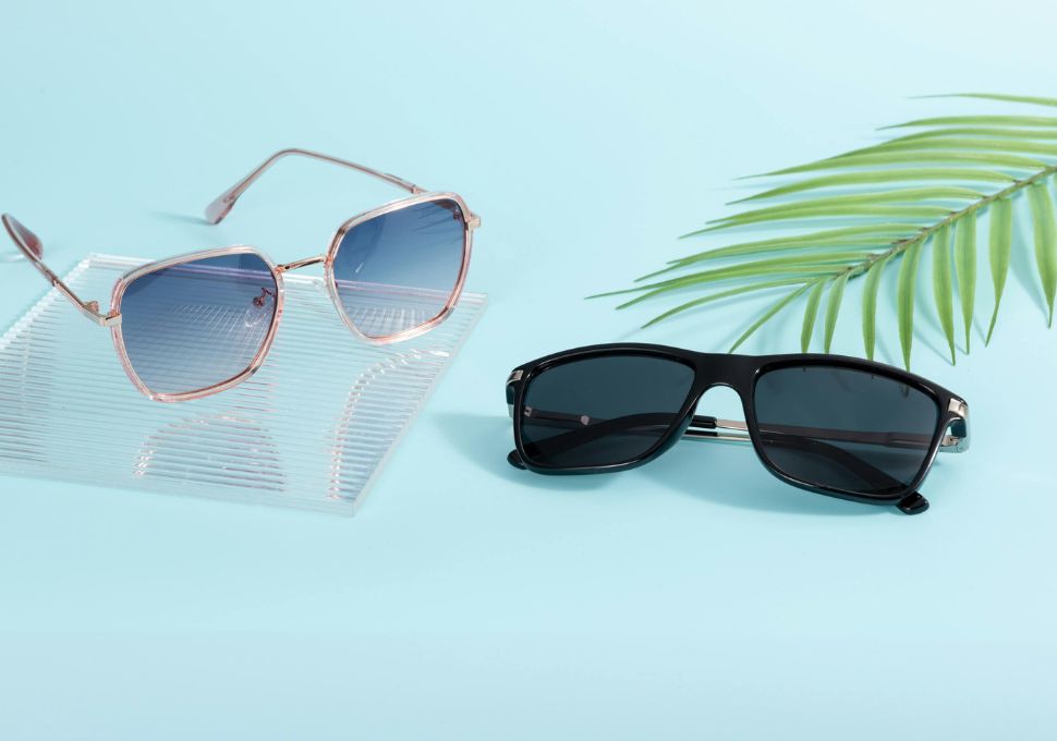 Dos pares de gafas polarizadas, unas con lentes rosas y otras oscuras, decoradas con hojas tropicales, perfectas para el clima soleado de Tenerife.